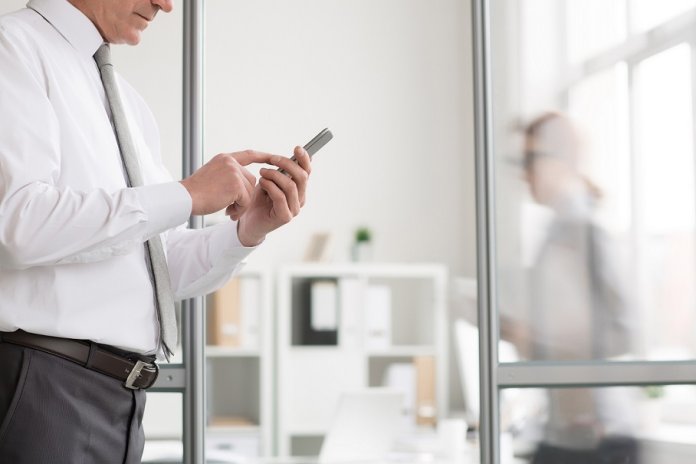 Image of man using his phone in an office